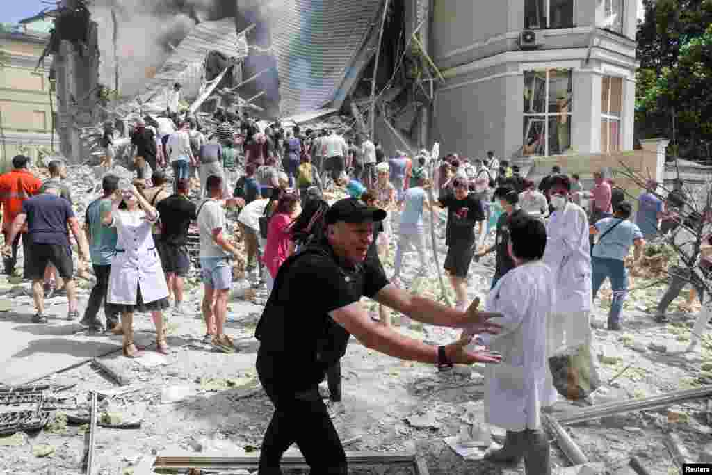 Люди, врачи и спасатели разбирают завалы одного из корпусов детской больницы "Охматдет" в Киеве, по которой российская армия нанесла удар, 8 июля 2024 года