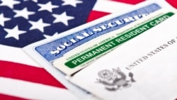 U.S. - United States of America social security and green card with US flag on the background. Immigration concept. Closeup with shallow depth of field, photo ©Shutterstock, undated