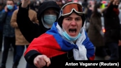 A man wearing a Russian flag shouts during a January 23, 2021 rally in St. Petersburg, Russia for the release of jailed Russian opposition leader Aleksei Navalny .