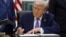 U.S. President Donald Trump signs an executive order in the Oval Office of the White House